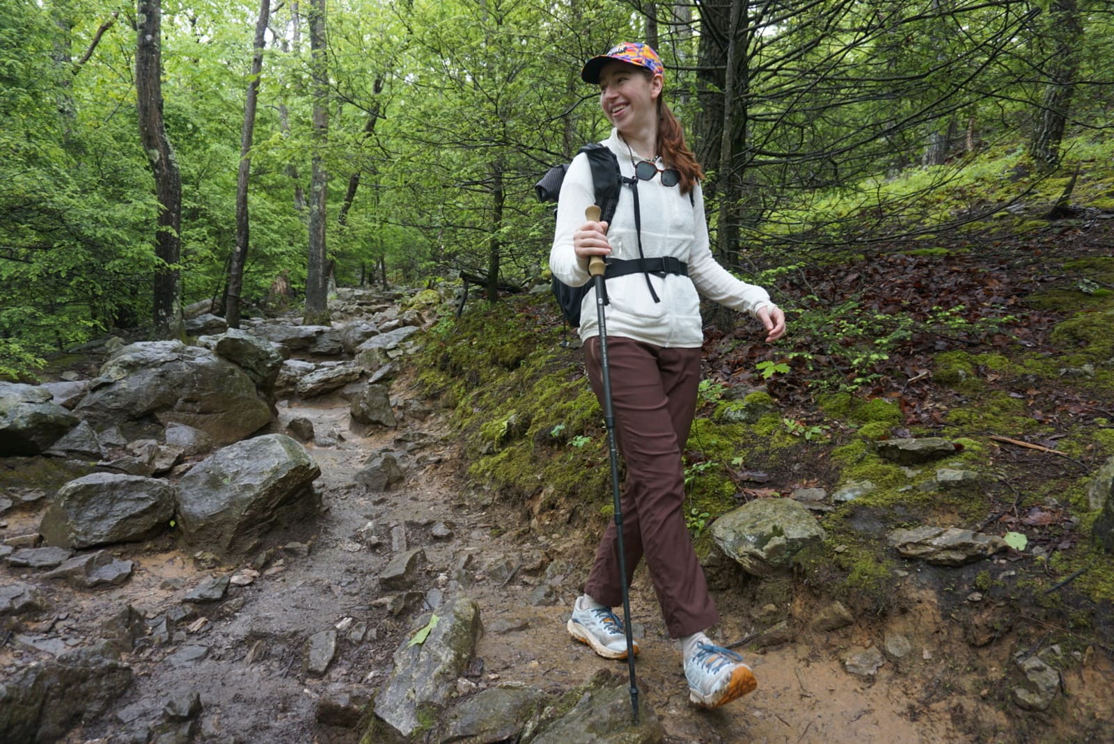 Woman walks down a trail in a white jacket