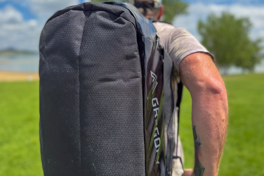 Person wearing the Gregory Alpaca 60 as a backpack while walking near a lake.