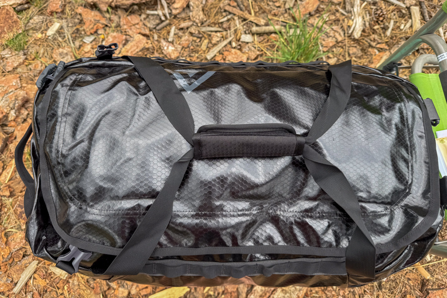 Black Gregory Alpaca 60 duffel viewed from above, showing the top carry handles and glossy recycled polyester ripstop fabric.