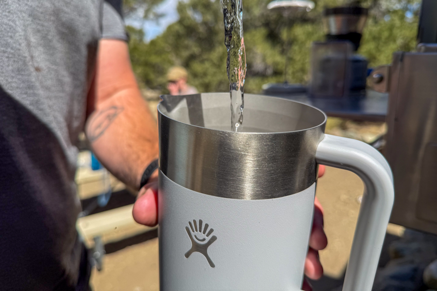 Hot water being poured into the a French press at camp.