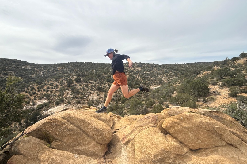 Someone jumping across desert rocks in the Saucony Peregrine 16
