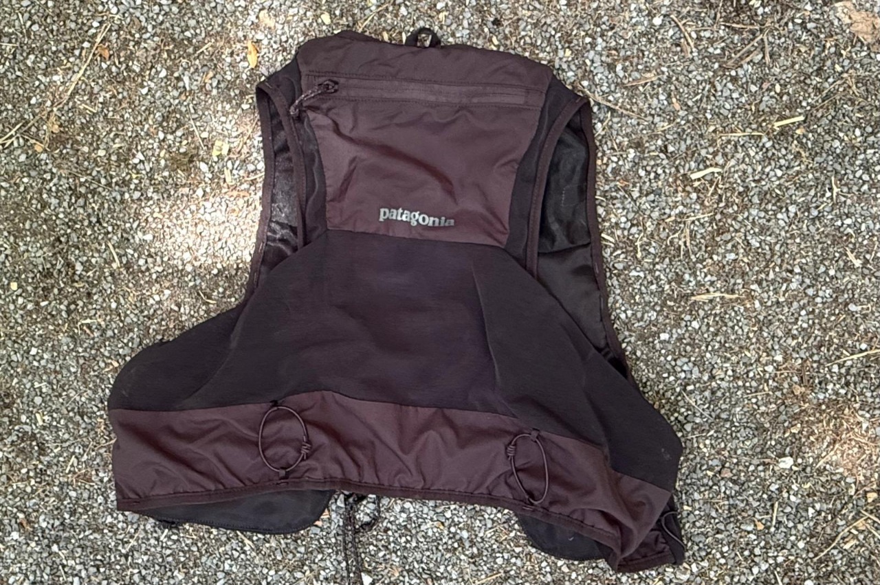 A black running vest lying on the ground.