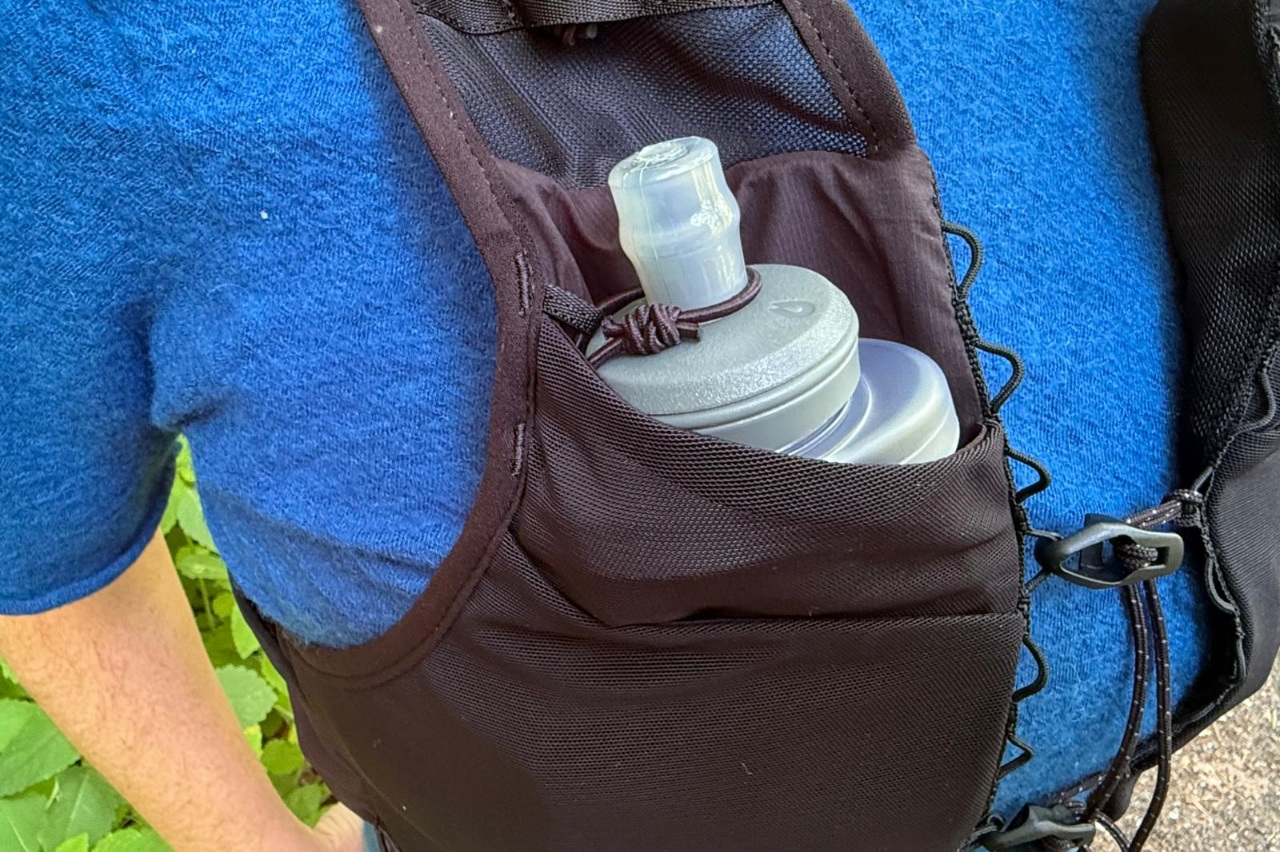 Close-up image of a water flask pocket on a black running vest.