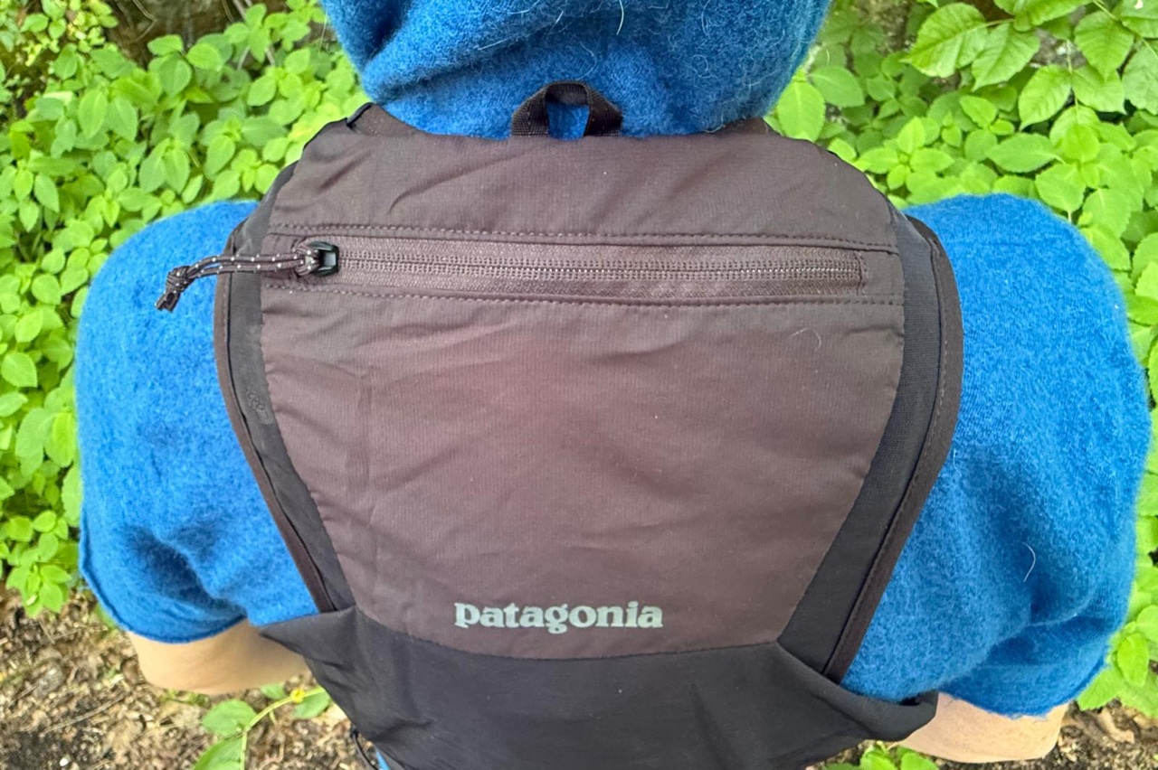 Close-up image of a rear zippered pocket on a black running vest.