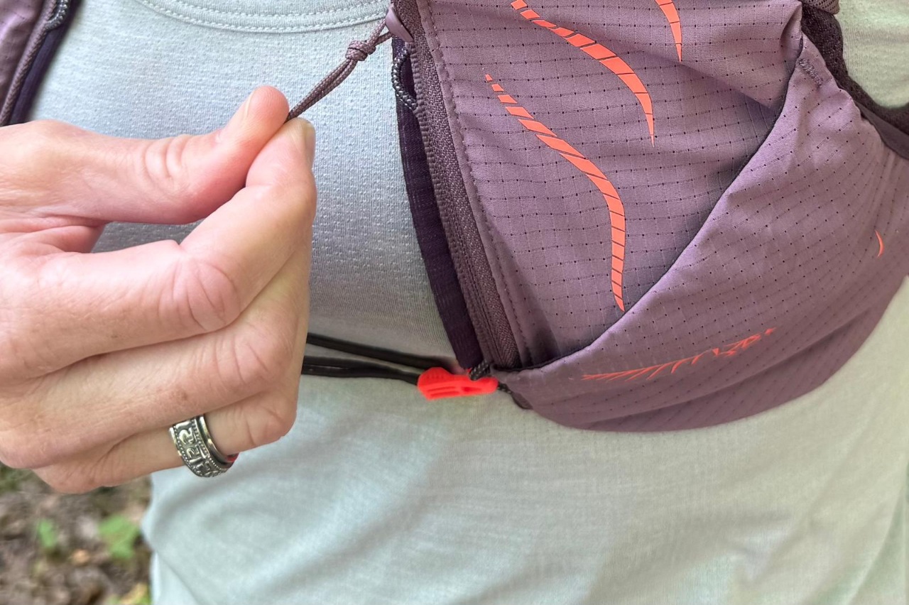 Close-up image of a zippered pocket at the front of a purple running vest.