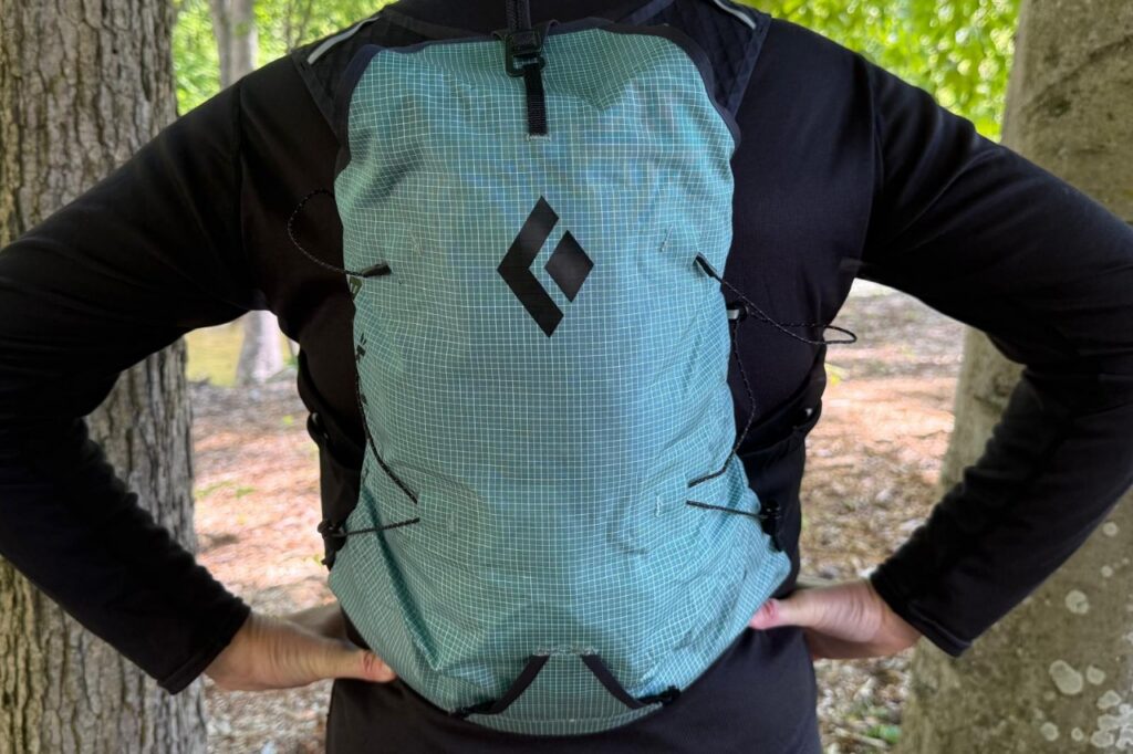 Close-up image of a blue running vest from the back. The person wearing it has her hands on her hips.