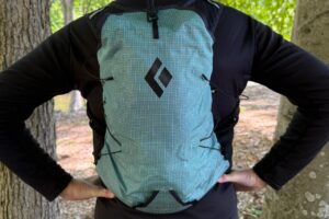 Close-up image of a blue running vest from the back. The person wearing it has her hands on her hips.