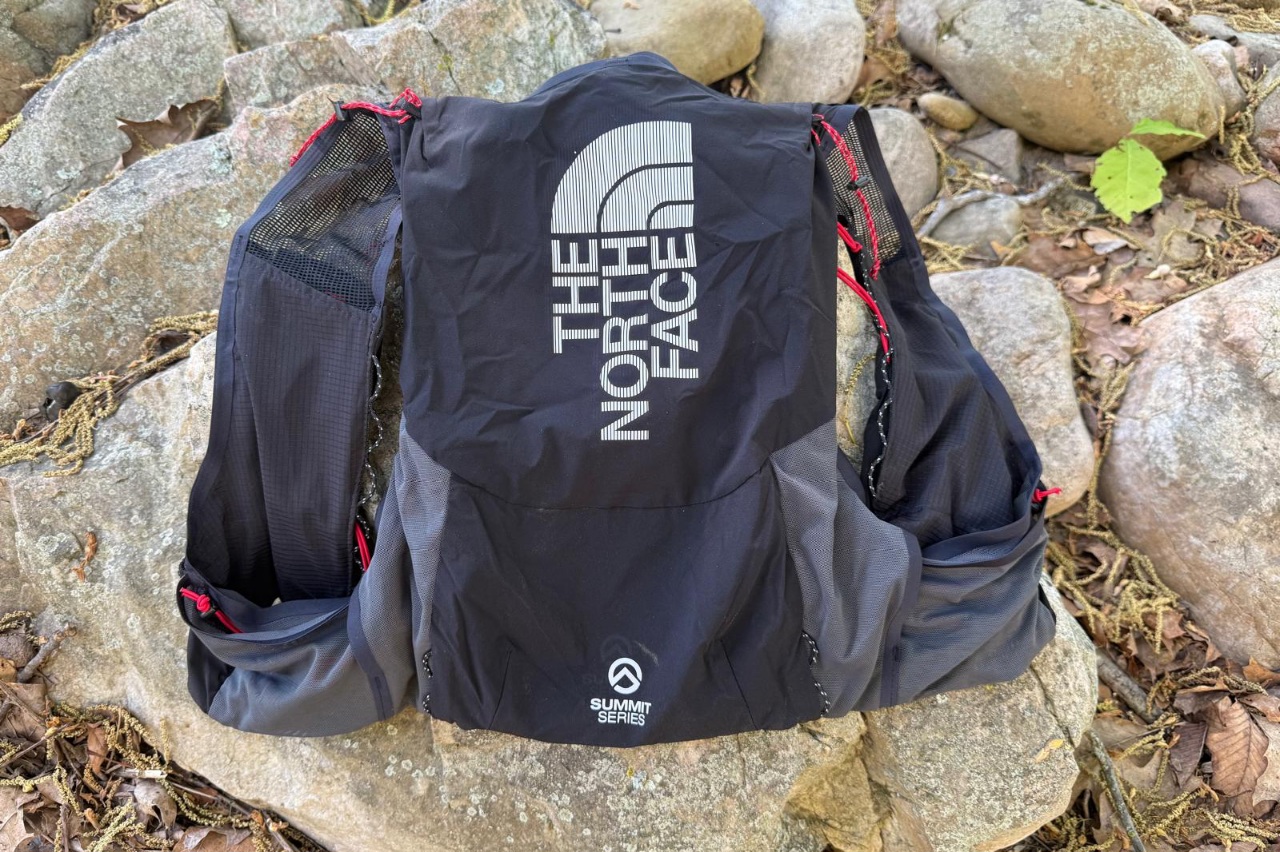 A black running vest lying on rocks, showing the fabrics and overall structure.