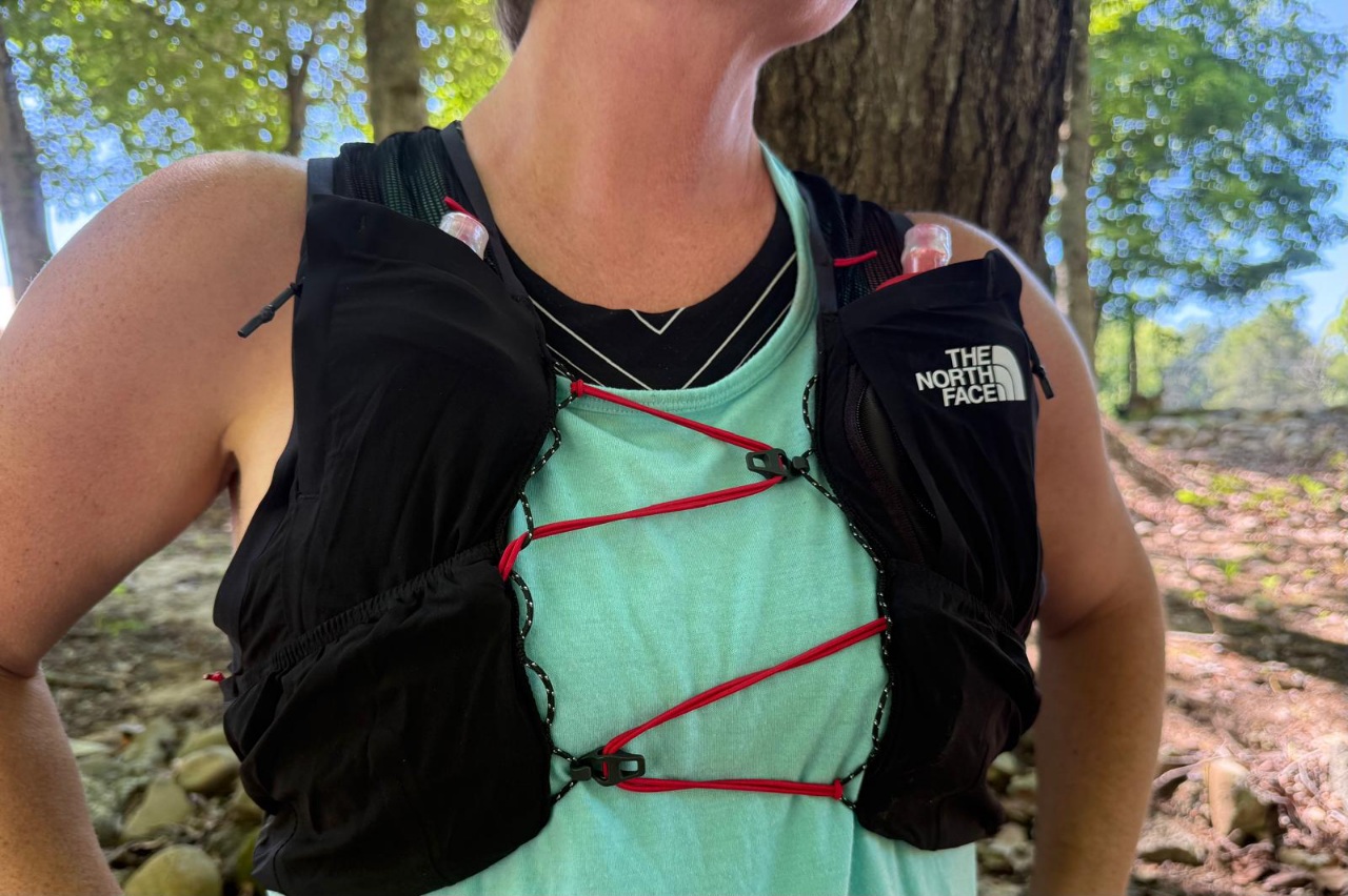 Close-up image of the sternum straps on a black running vest. The straps are crisscrossing across the wearer's chest.