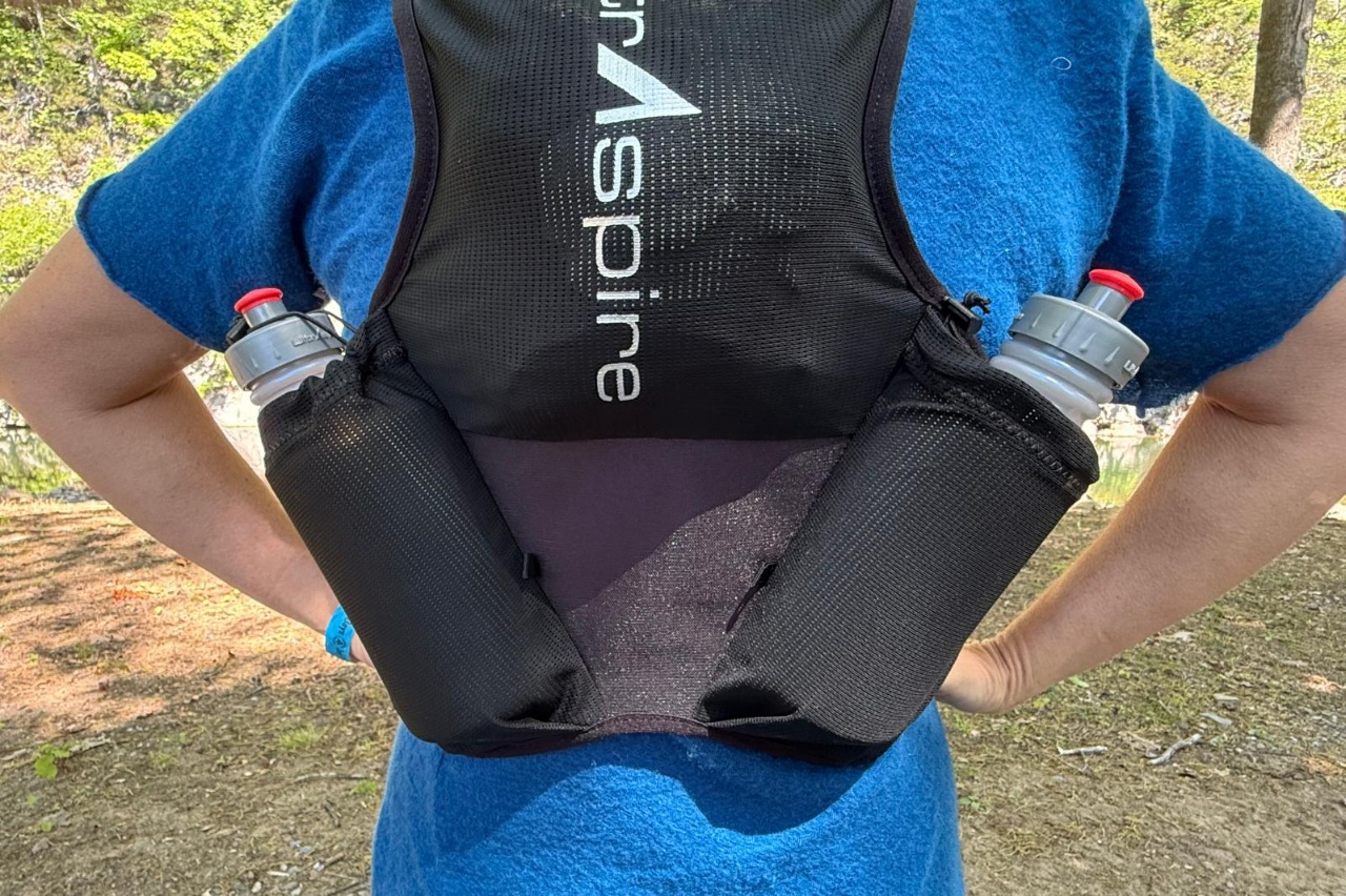 Close-up image of the back of a black running vest showing off the fabrics and dual water bottle pockets.
