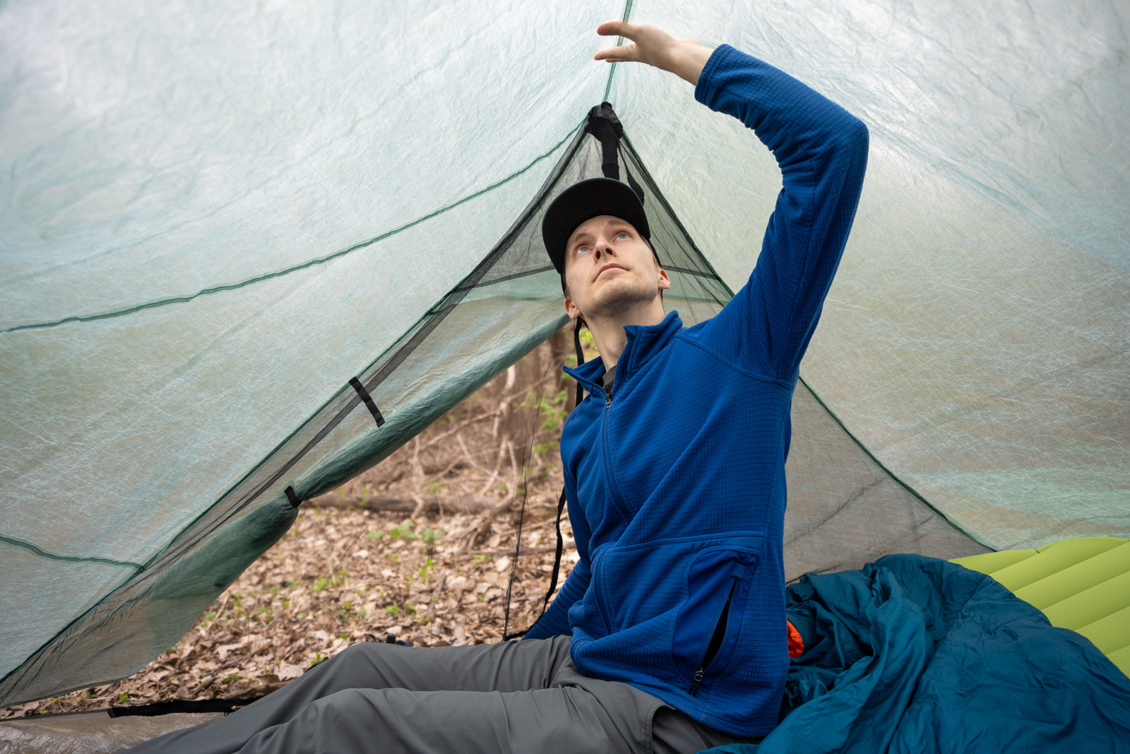A man sits up in a tent