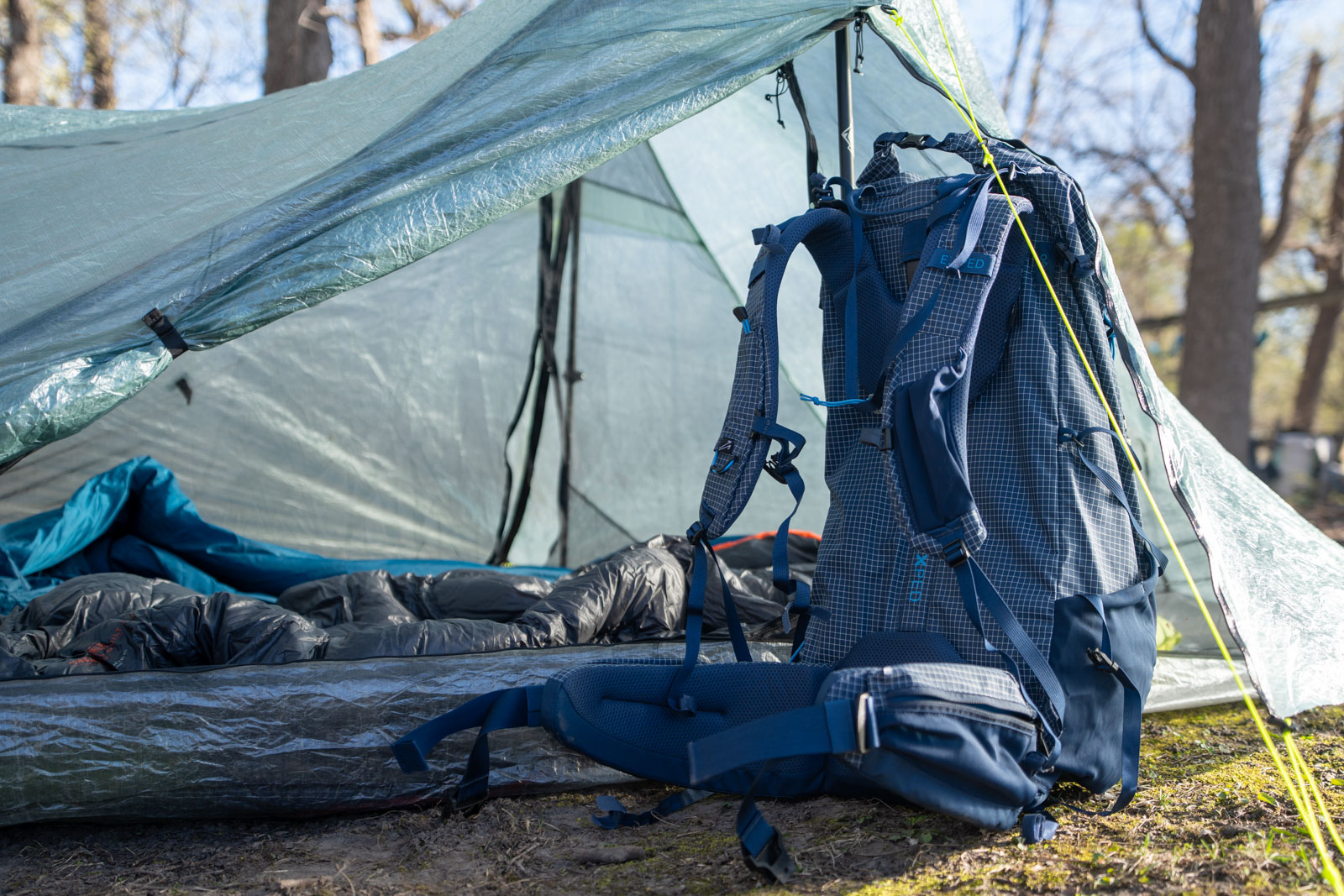 a blue backpack sits in a tent vestibule