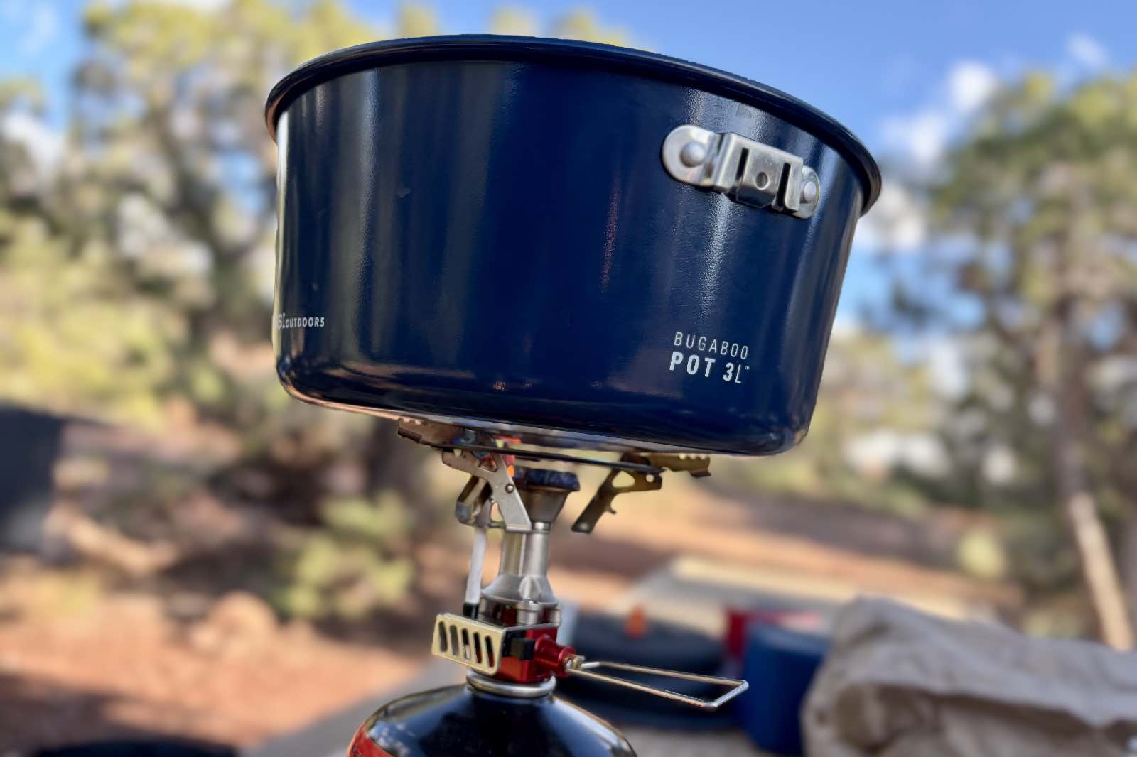 a blue pot sits on a camp stove
