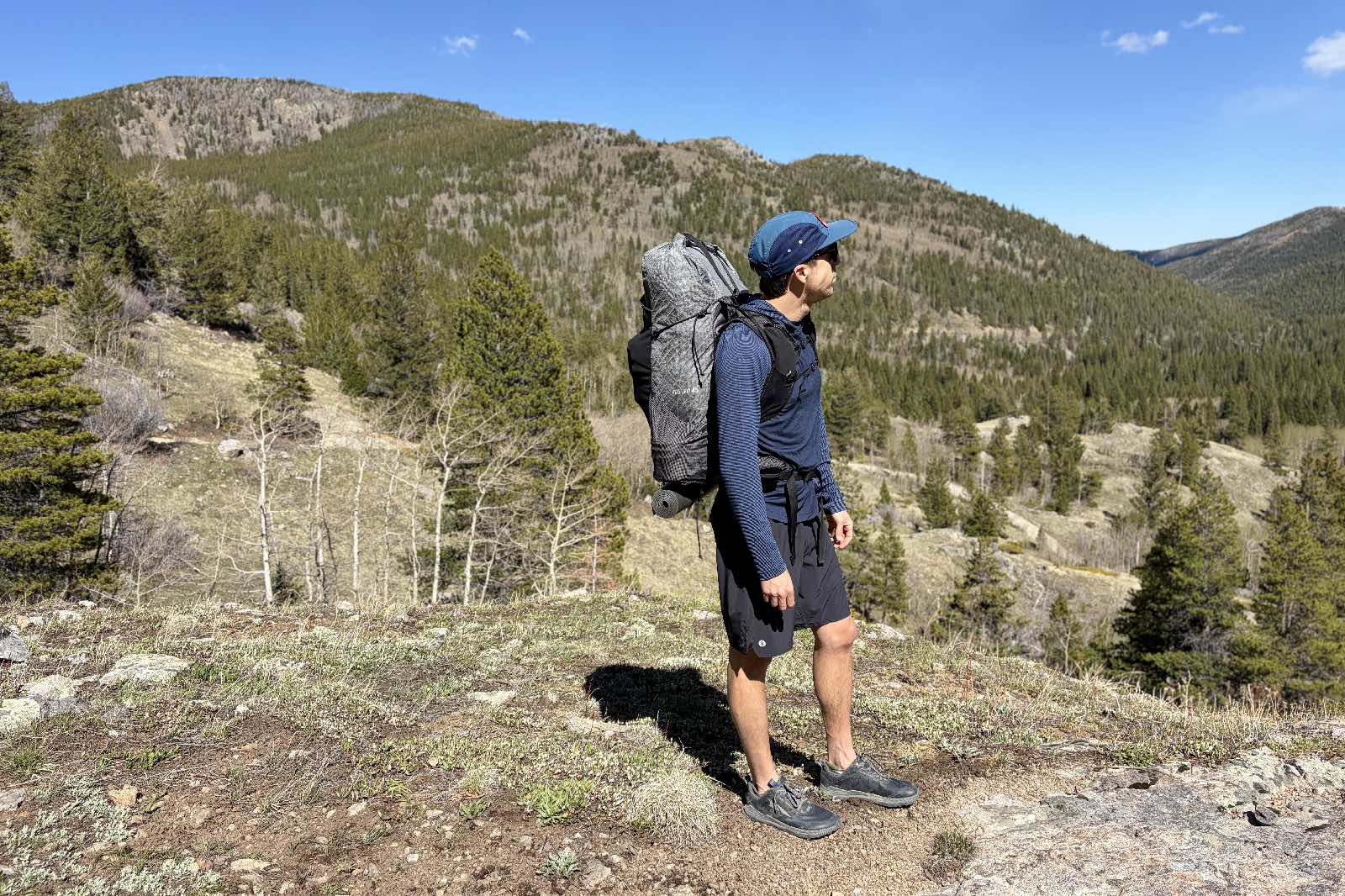 Un excursionista se encuentra en el bosque con una mochila.