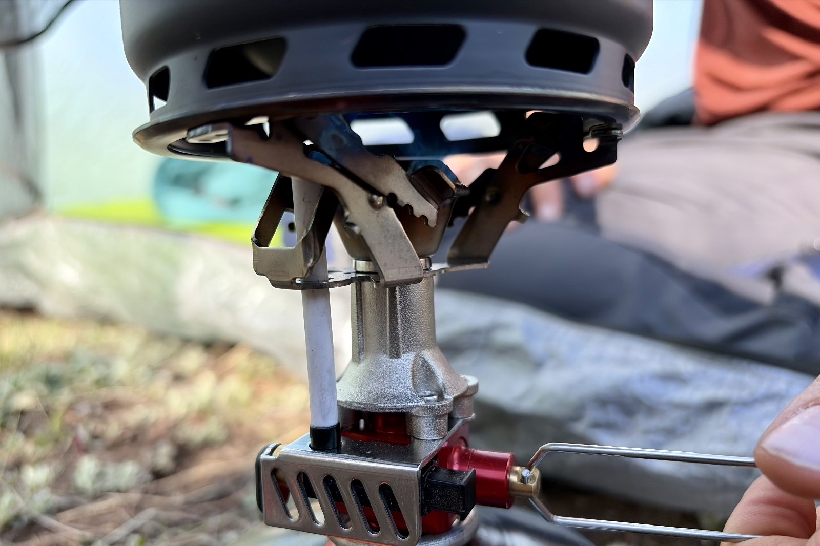 Close-up image of a backpacking stove igniting a flame under a pot.