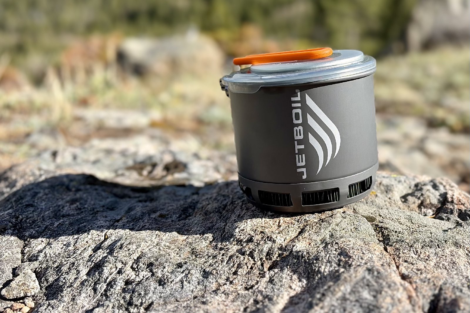 Close-up image of a camping cook set on a rock.
