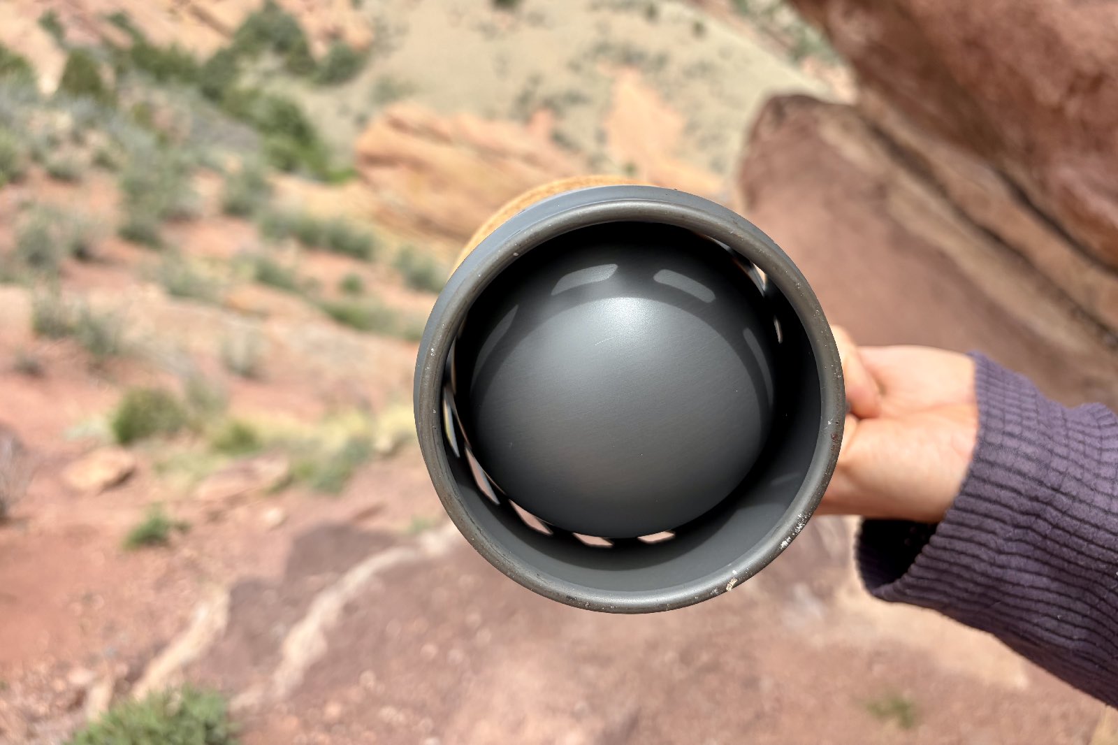A hiker shows the round bottom of a backpacking pot.