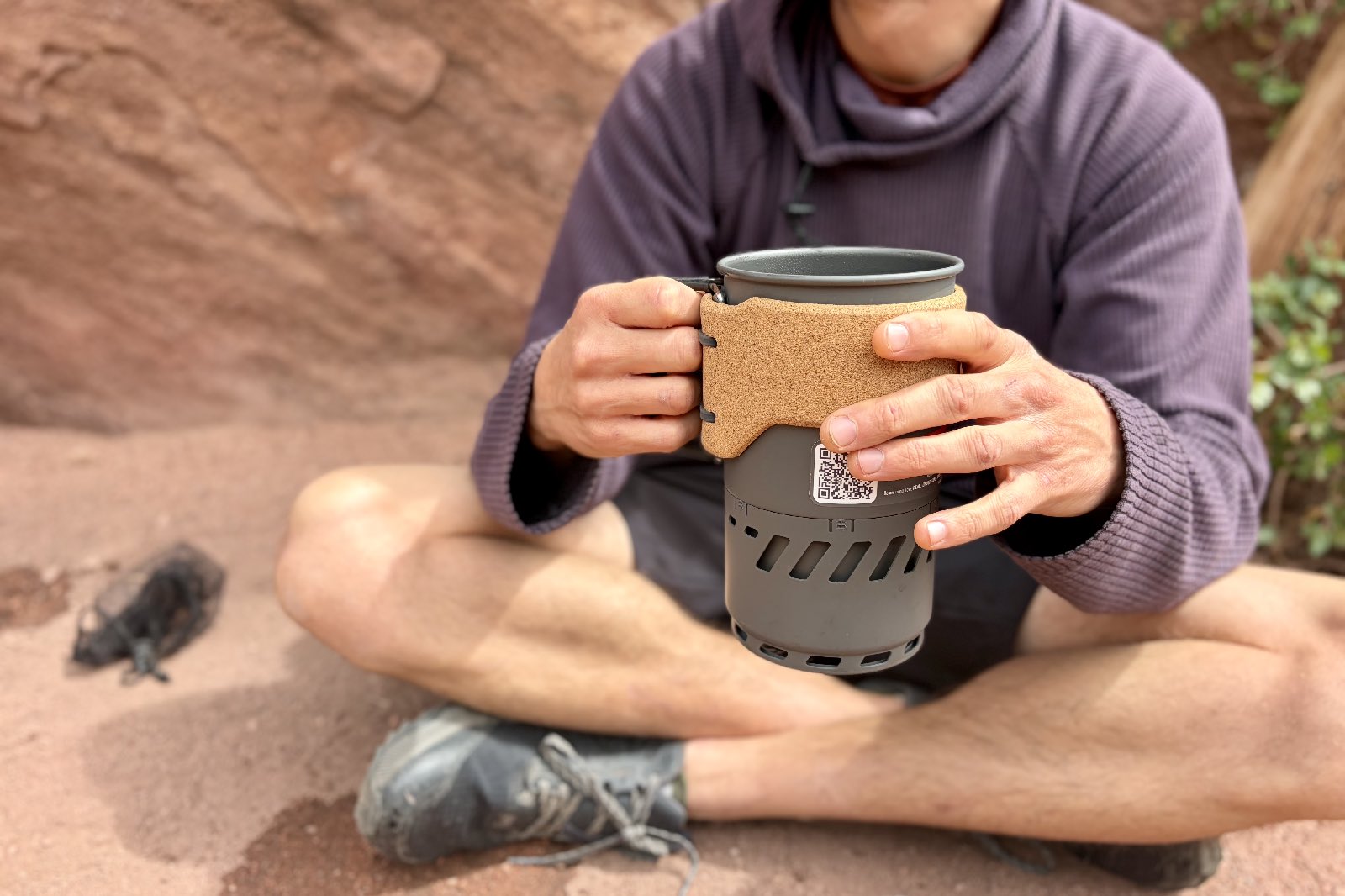 A hiker holds a backpacking pot with both hands.