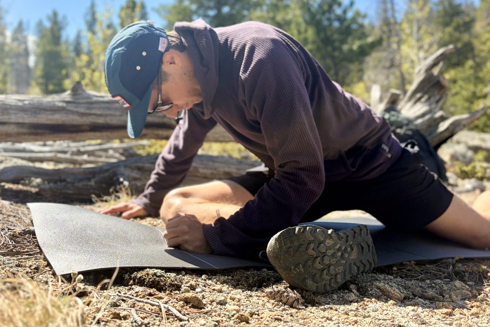 a hiker stretches on a grey foam pad