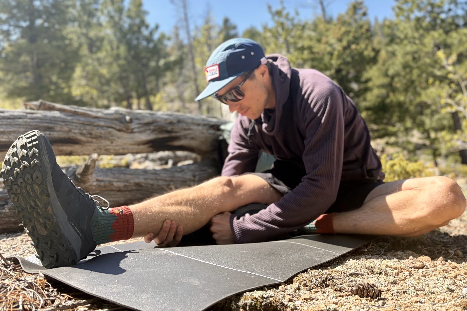 a hiker stretches on a grey foam pad