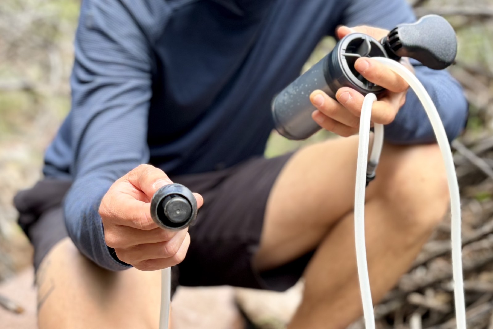 A hiker shows a close up of a water filter inlet.