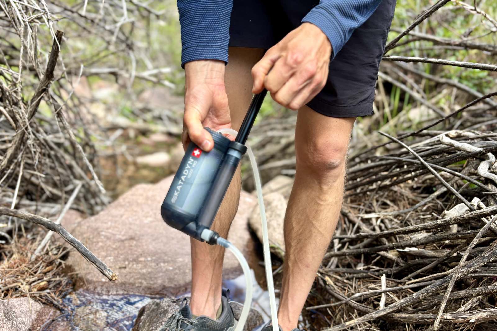 a close up of a hiker pumping a water filter
