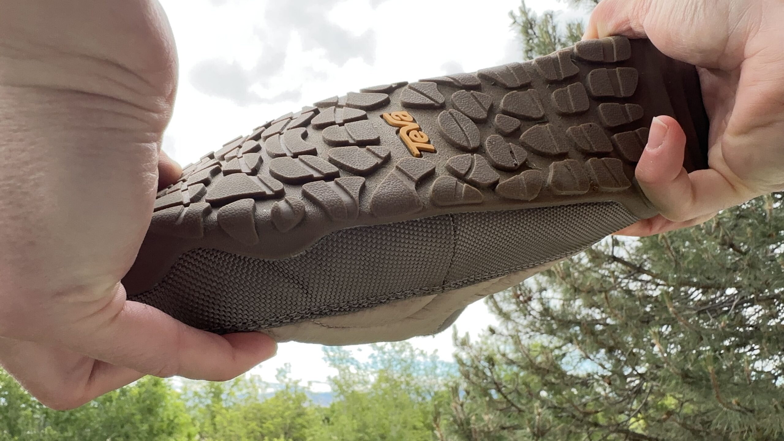 A woman twists a shoe in front of the camera to show how much support it will provide.