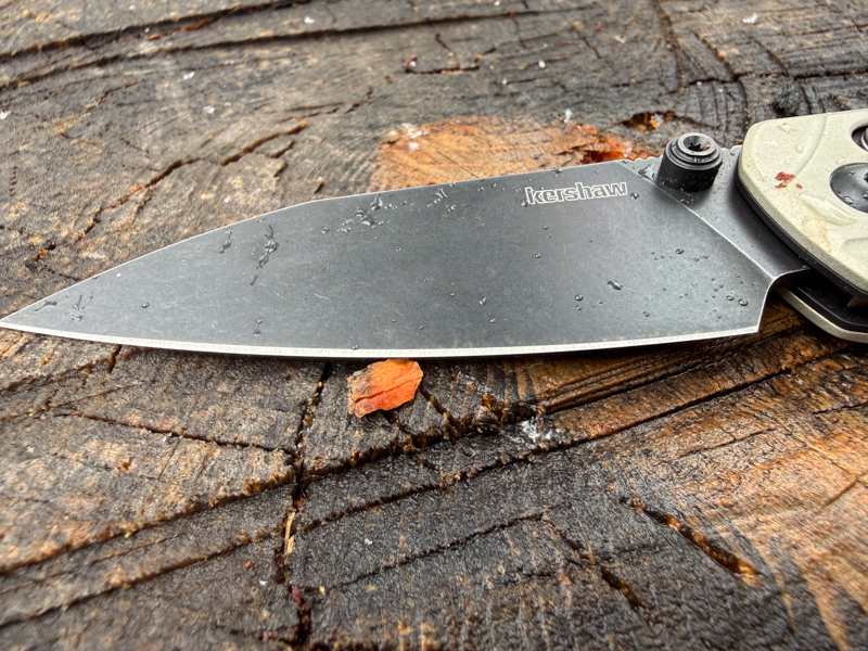 Close-up of the Kershaw Bel Air blade with water droplets on the dark blade finish during wet-weather testing.
