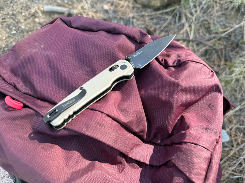 Kershaw Bel Air resting open on a maroon backpack to show scale, carry size, and profile.