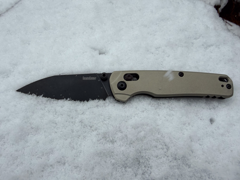 Kershaw Bel Air resting partially open in fresh snow to show cold-weather and wet-condition testing.