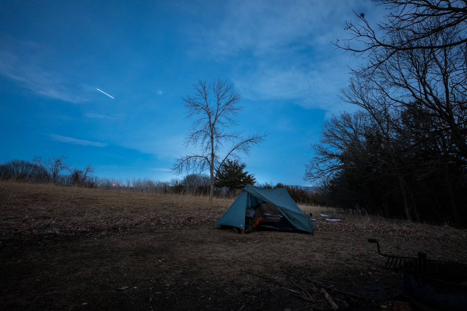 A tent in a field under a starry night