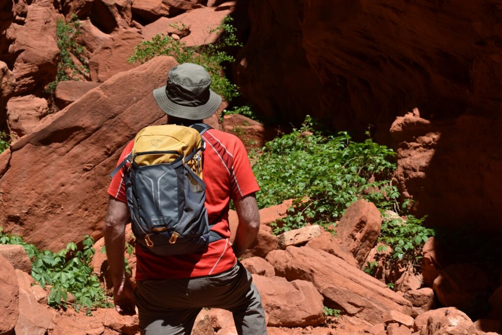 Our gear analyst hiking through a redrock slot canyon with the Osprey Sportlite 20 on his back.
