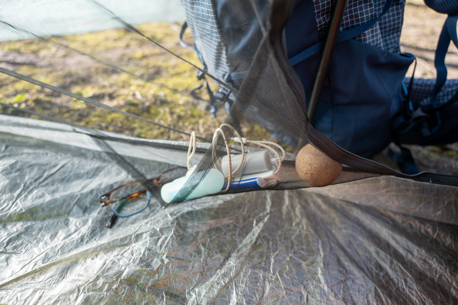 A collection of items falls out of a pocket in a tent