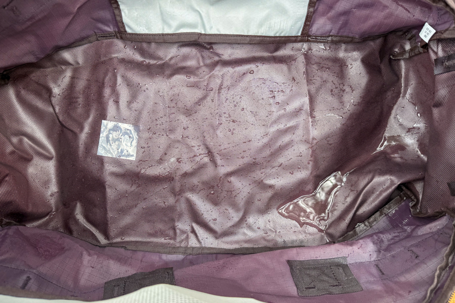 Interior of the REI Co-op Big Haul 60 with visible water droplets and moisture after weather-resistance testing.