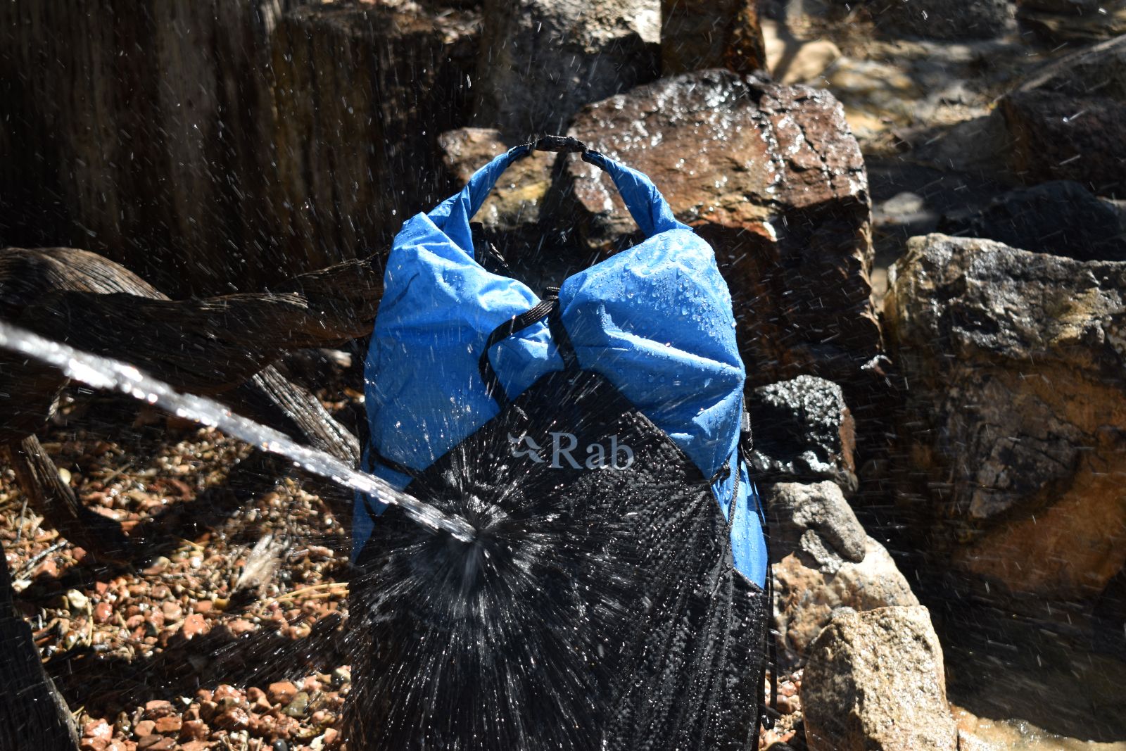 Our gear analyst sprays the Rab Syclon XP with a hose to test its waterproofing.