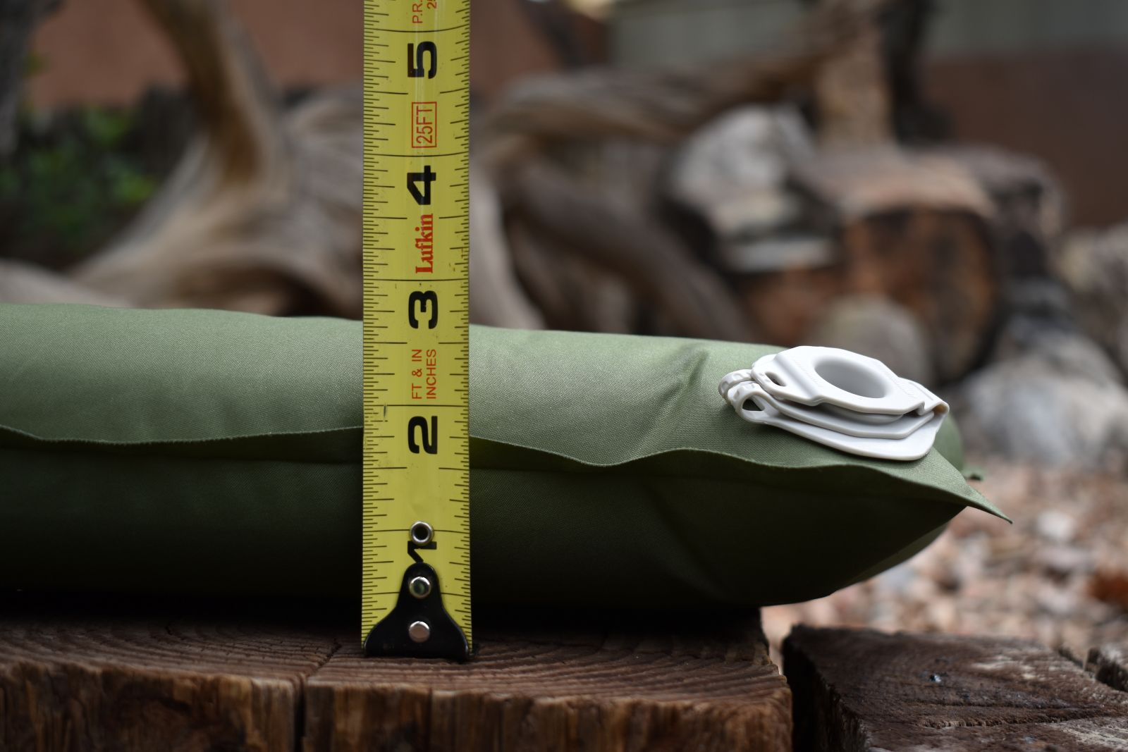 A tape measure in front of the air mattress is shows its between 2.5 and 3 inches thick