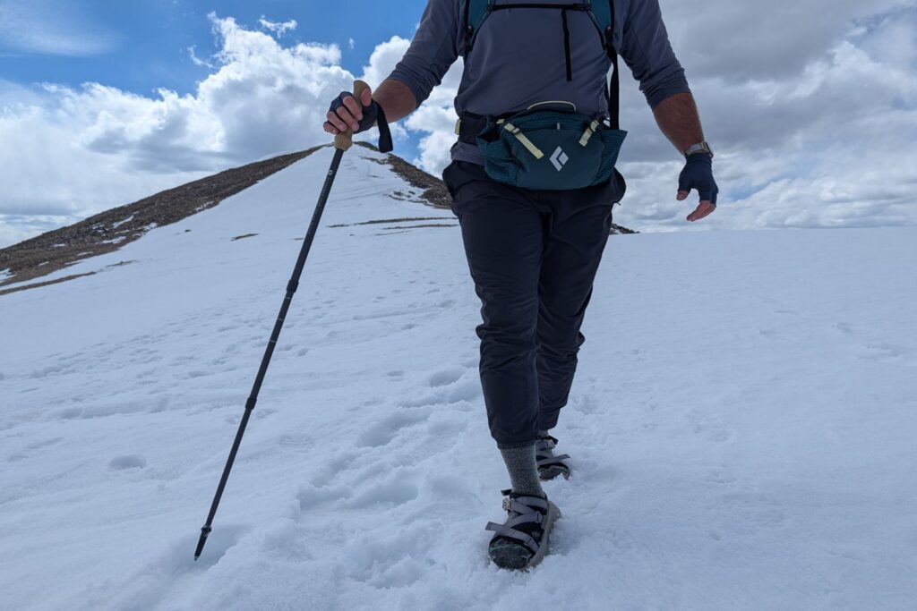 Hiking down a snow field on Mount Democrat in the Hoka Infini Hike TC sandals.