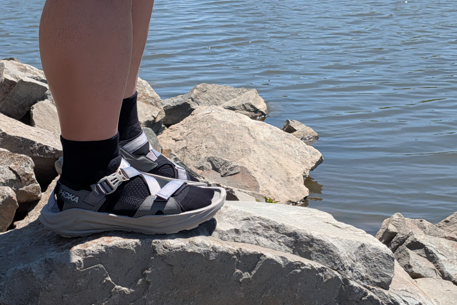 Hoka Infini Hike TC's next to a body of water.