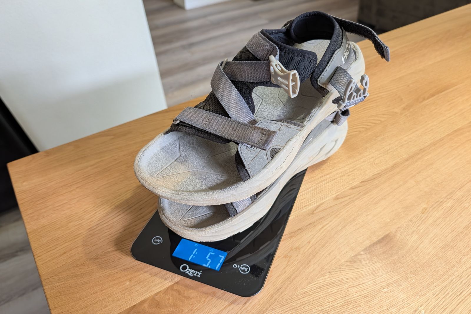 Weighing the Hoka Infini Hike TC's on a kitchen scale.