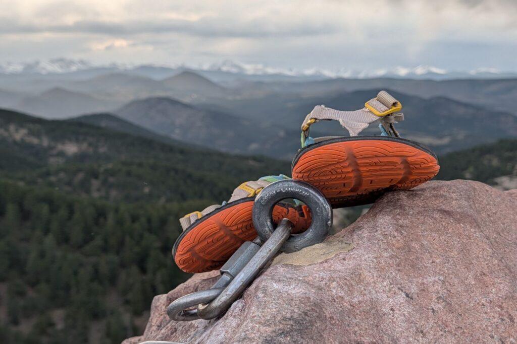 The Lems Switchback Knit resting on top of the rappel bolt of the first flatiron summit.