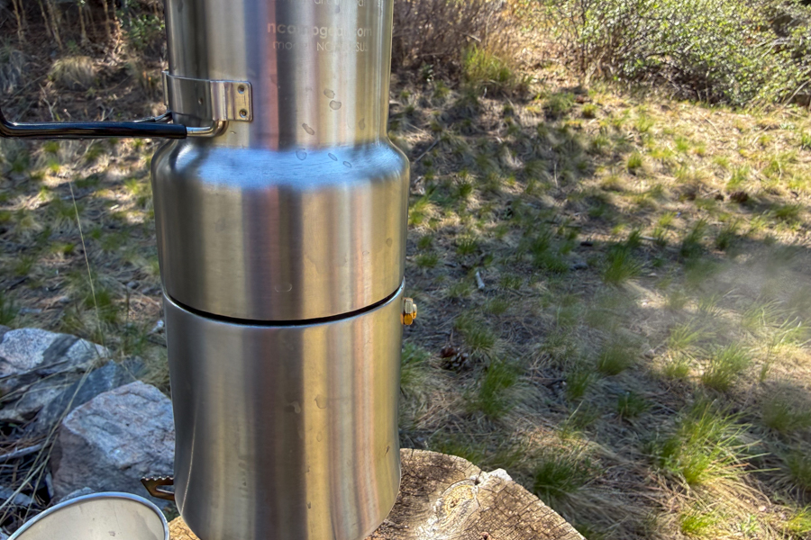 Close-up of steam venting from the side valve of a coffee maker during brewing.