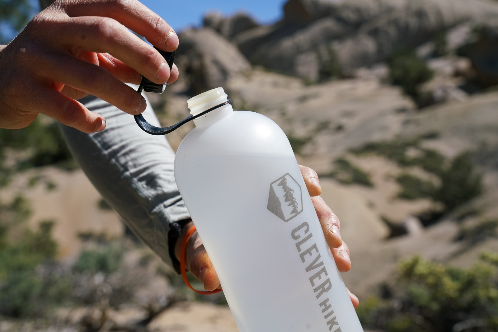 A close up of a person opening the cap of a water bottle.