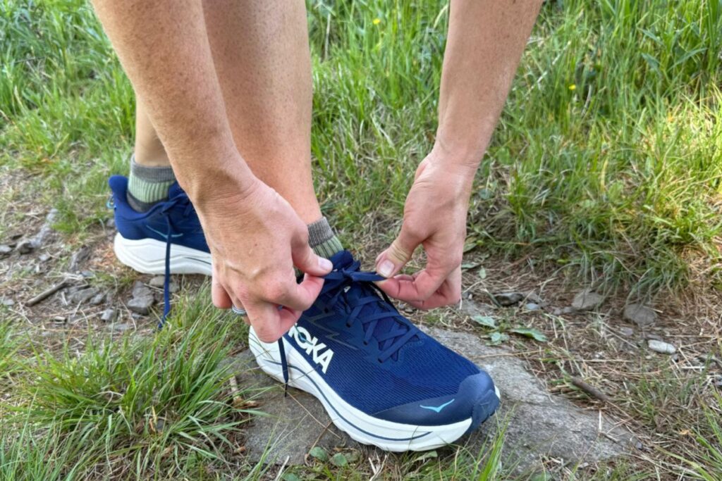 Close up of a runner tying the Hoka Challenger 8