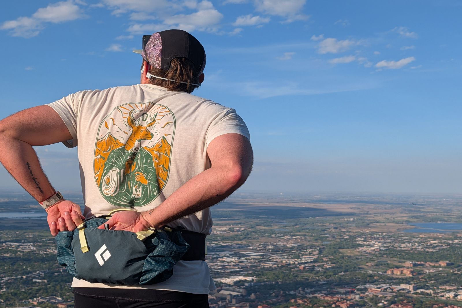 Reaching into a blue lumbar pack while overlooking Boulder, Colorado.