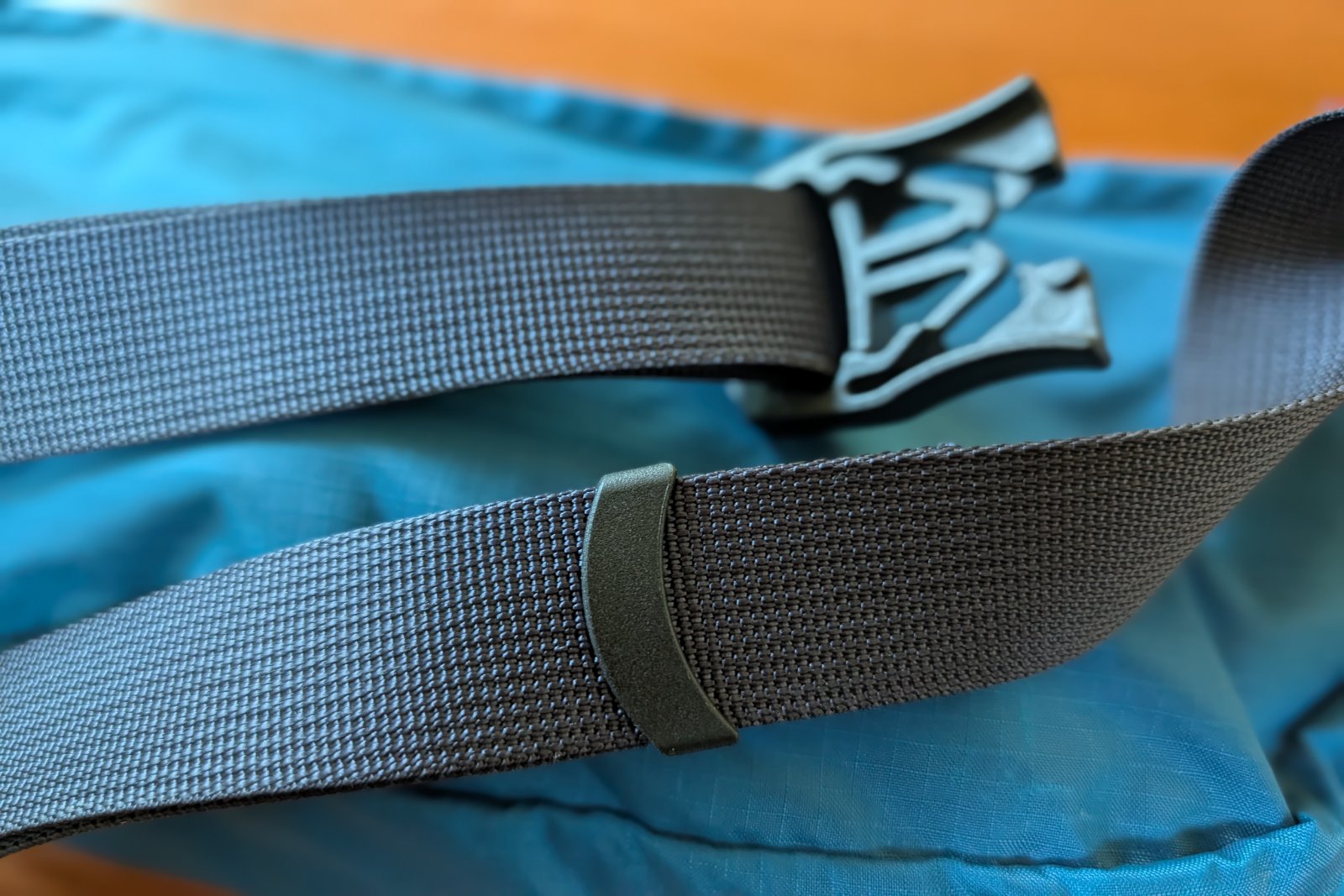Showing the the strap keeper and strap material on a blue fanny pack.