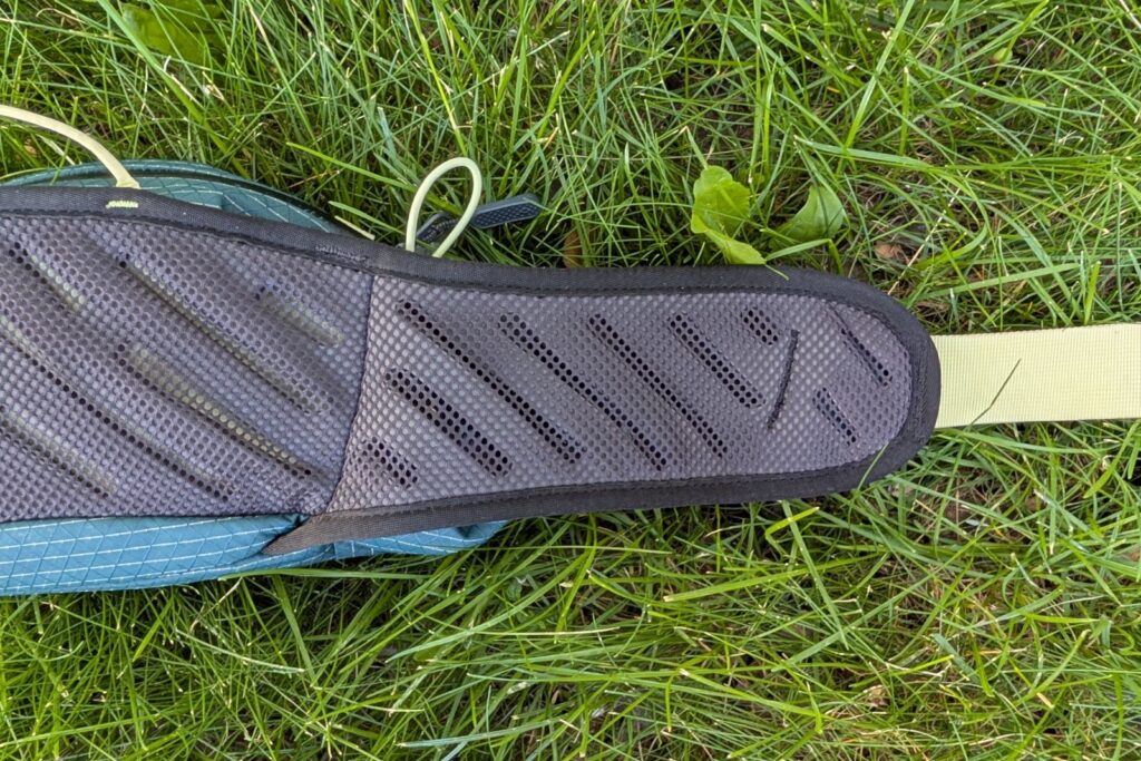 Showing off the ventilated mesh harness and strap of a blue lumbar pack.