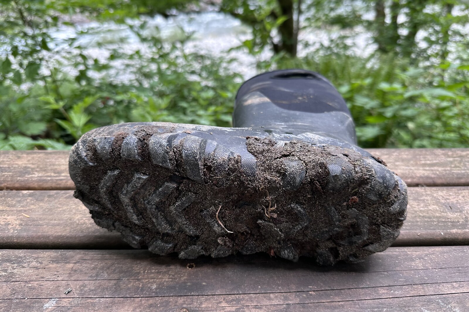 Bottom view of the large lugs on a pair of tall black rain boots.