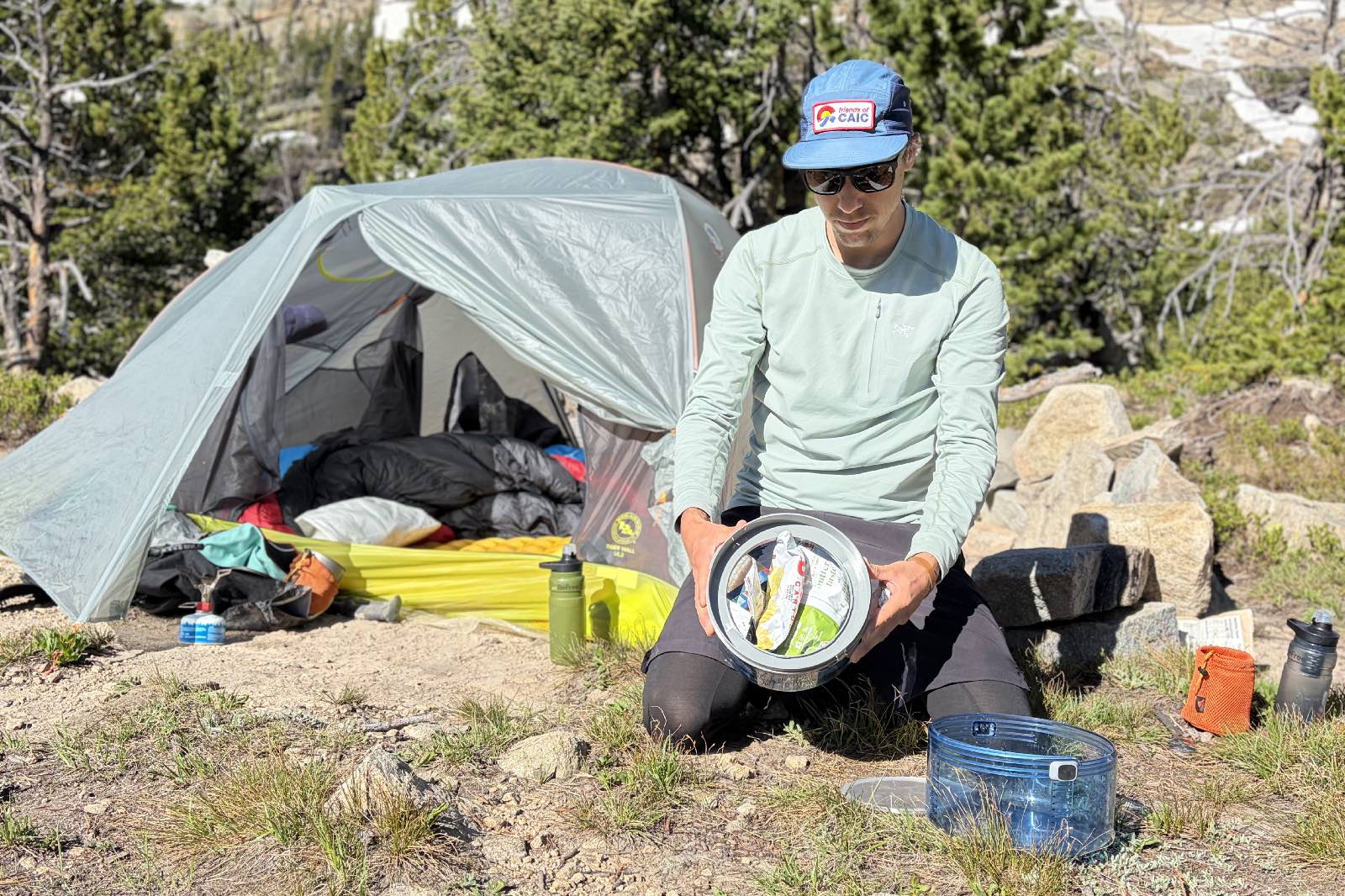 A hiker shoes the inside of his bear canister containing food.