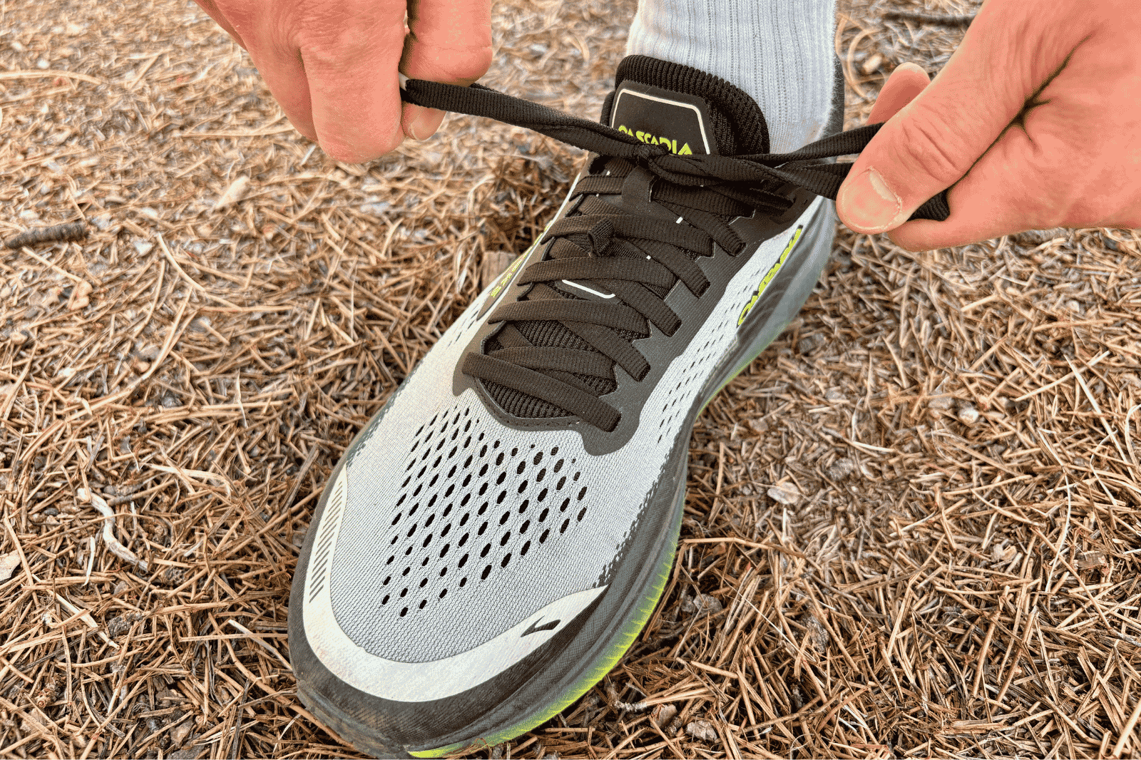 Closeup of a man tying a trail running shoe