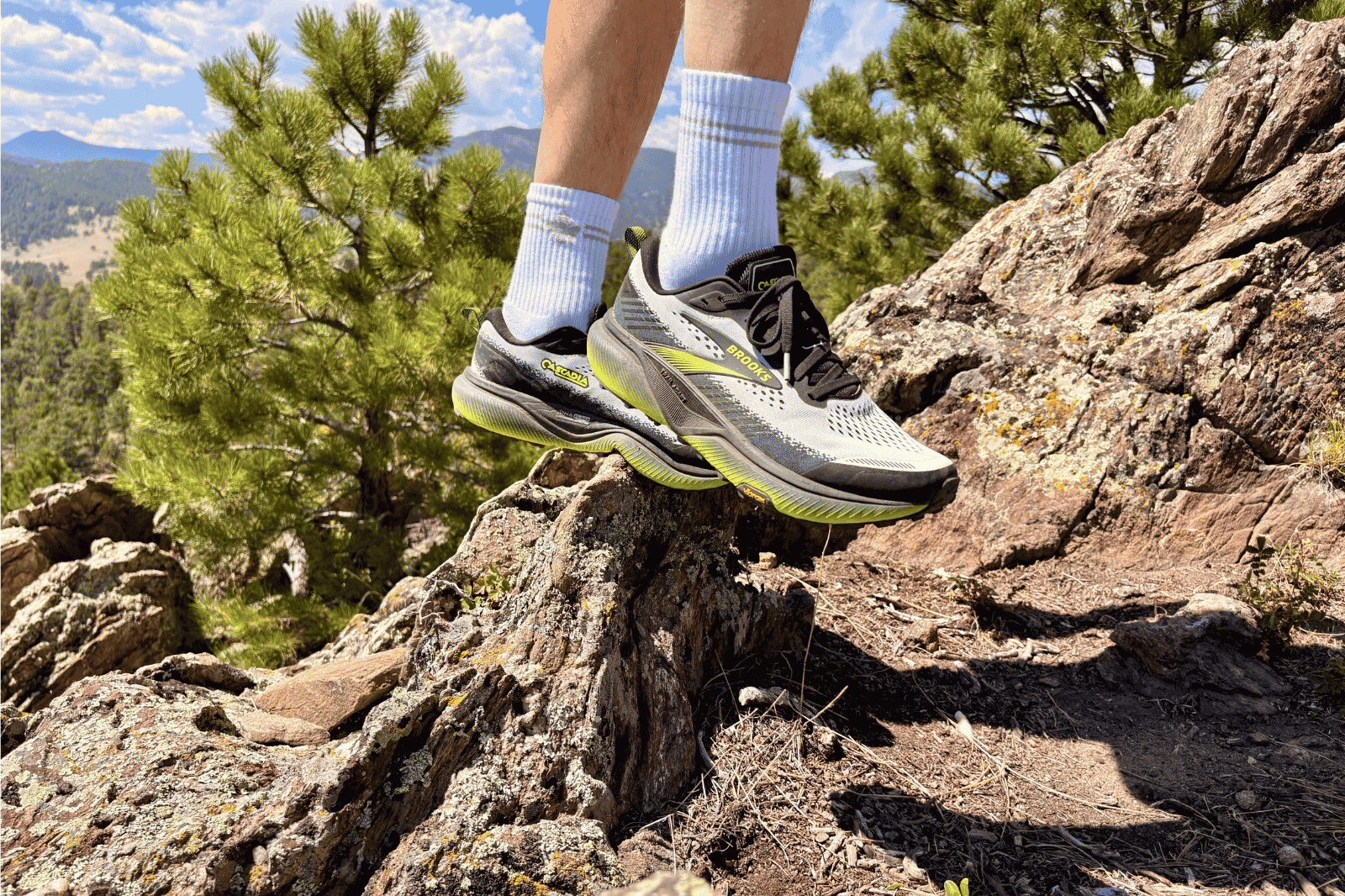 Closeup of a man's feet in trail running shoes, stepping on a rock